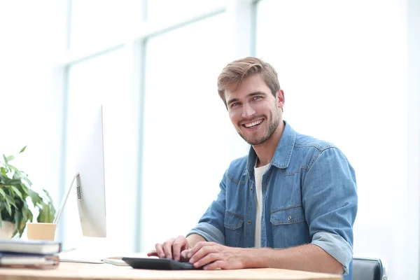 Glücklicher Geschäftsmann sitzt an seinem Schreibtisch — Stockfoto