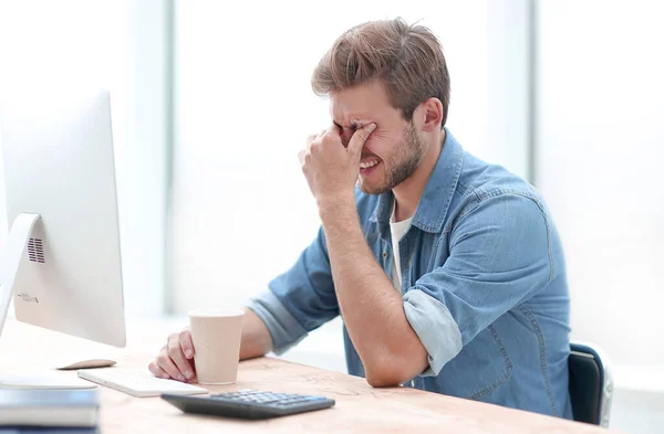 Nahaufnahme. Jungunternehmer mit Kaffeetasse sitzt am Schreibtisch. — Stockfoto