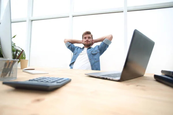 Pensativo joven empresario sentado en su escritorio . — Foto de Stock