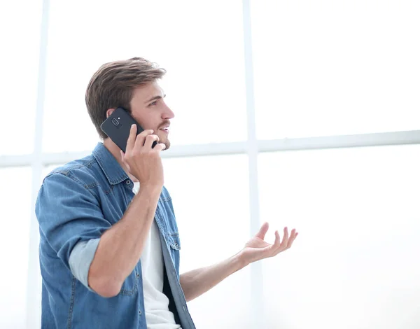 Joven empresario hablando en un teléfono inteligente en la oficina — Foto de Stock