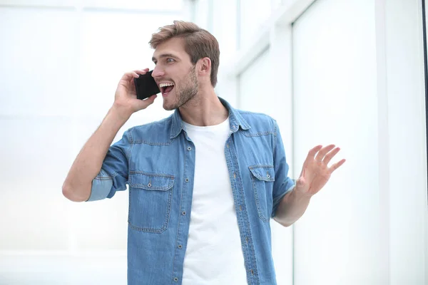 Ung man pratar i telefon stående i Office — Stockfoto