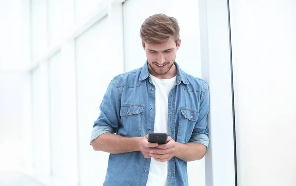 Joven hablando por teléfono parado en la oficina — Foto de Stock