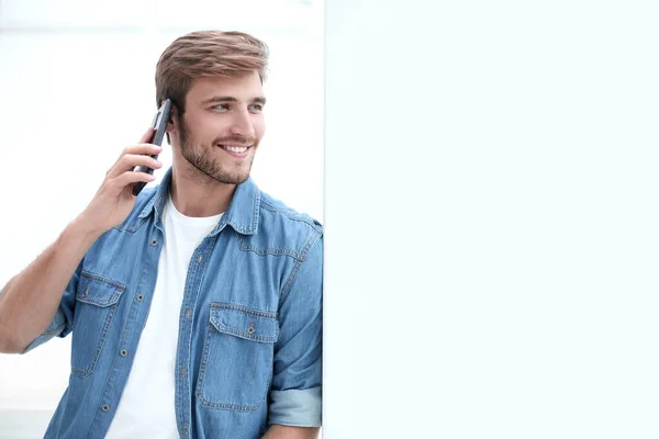 Fiatal férfi beszél a telefon áll hivatalban — Stock Fotó