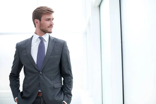Fecha. focado jovem empresário em pé no escritório — Fotografia de Stock