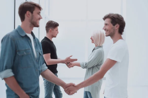 Compañeros de trabajo estrechando la mano en el vestíbulo de la oficina . — Foto de Stock