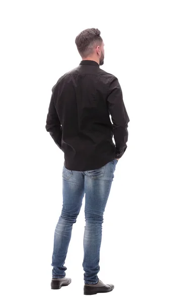 Rear view. young man in jeans looking forward — Stock Photo, Image