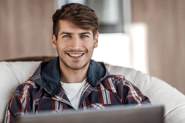 Close up. dreaming young man sitting in front of an open laptop — Stock Photo, Image