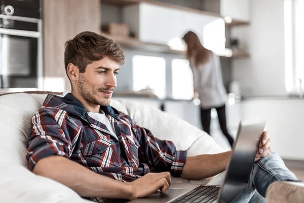 Fecha. um jovem trabalha em um laptop na cozinha — Fotografia de Stock