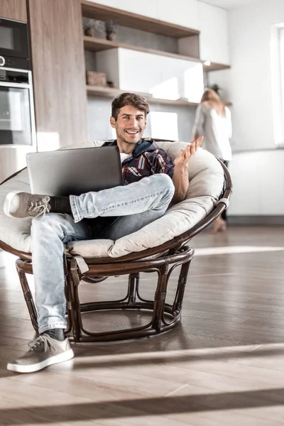 Young man uses a laptop in his modern apartment. — Stock Photo, Image