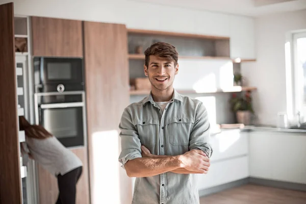 Joven guapo de pie en su cocina . — Foto de Stock