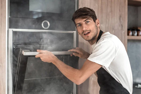 Joven emocional de pie cerca del horno roto — Foto de Stock