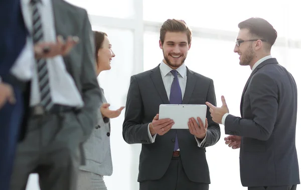 Compañeros de negocios felices en la oficina moderna usando tableta —  Fotos de Stock