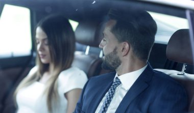 Genç iş adamları arabada birlikte çalışıyorlar.