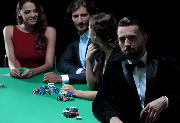 Man with cigar looking up from poker game in casino — Stock Photo, Image