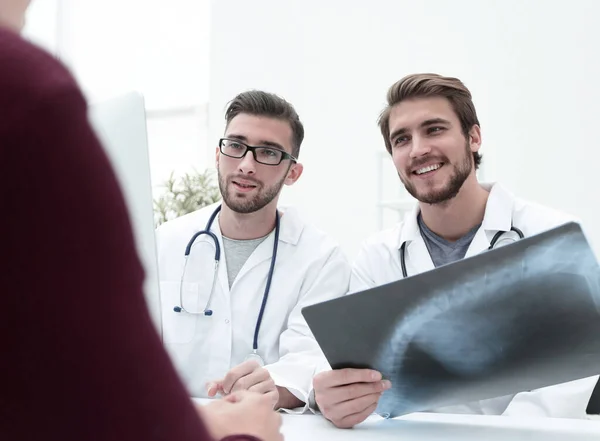 Två läkare undersöker en röntgenbild av en patient — Stockfoto