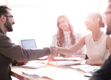 İş adamı iş ortaklarının el sıkışmasına bakıyor