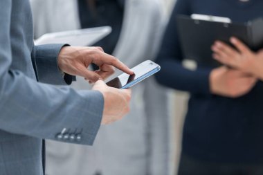 Kapat. Akıllı telefonlu bir iş adamı meslektaşıyla konuşuyor..