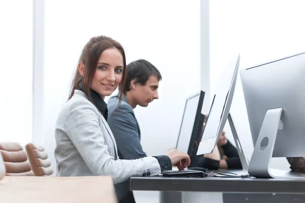 Μια νεαρή γυναίκα δουλεύει σε έναν υπολογιστή στο γραφείο.. — Φωτογραφία Αρχείου