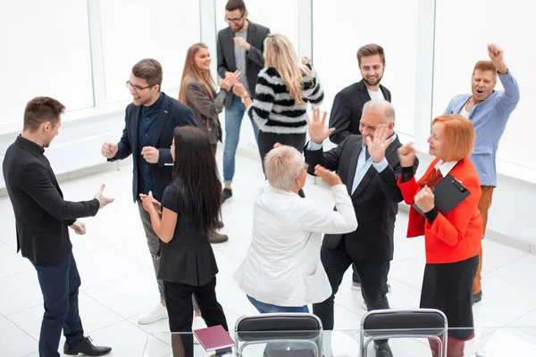 Business team viert een triomf met de armen omhoog in de moderne o — Stockfoto