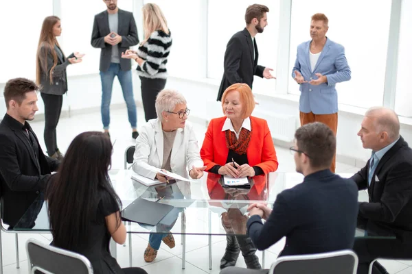 Zakelijke mensen zitten rond het bureau in een vergadering en maken — Stockfoto