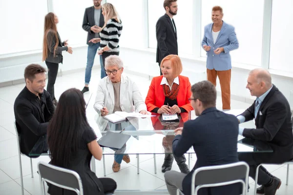 Zakelijke mensen zitten rond het bureau in een vergadering en maken — Stockfoto