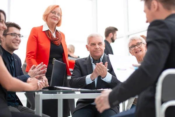 Ondernemers applaudisseren in vergaderzaal tijdens bijeenkomst — Stockfoto