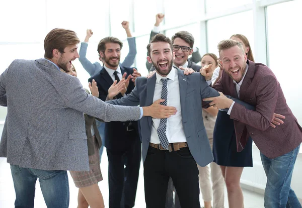 Grupo jubiloso de empleados felicitando a su líder por la victoria —  Fotos de Stock