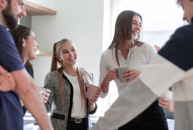 Gülümseyen arkadaşlar çay kupalarıyla buluşuyorlar.