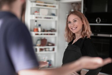 Genç ev hanımı buzdolabından bir şey alıyor.