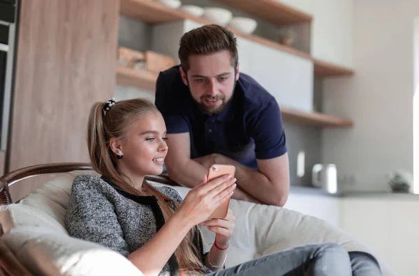 Glückliches junges Paar telefoniert zu Hause in der Küche — Stockfoto