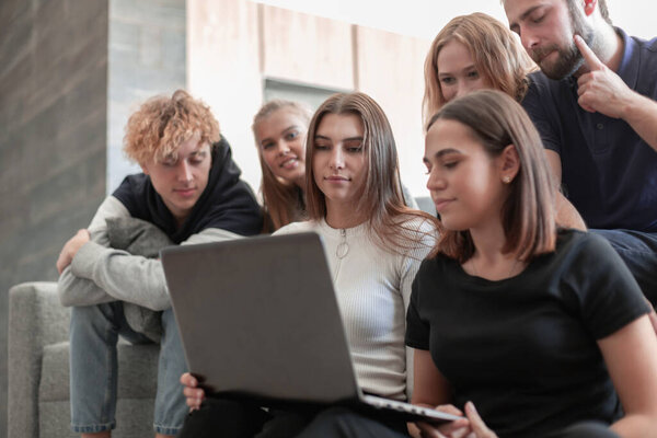 Group of young colleagues using laptop at office