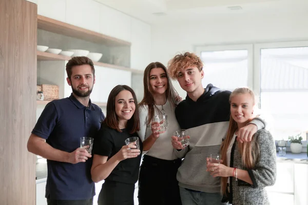 Grupo feliz de amigos em casa tomando bebidas — Fotografia de Stock