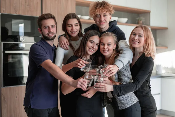 Groupe d'amis souriants prenant un verre dans la cuisine — Photo