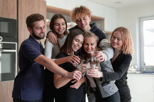 Groupe d'amis souriants prenant un verre dans la cuisine — Photo