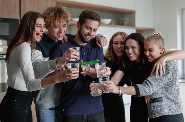 Joyeux jeunes amis ouverture bouteille de champagne — Photo