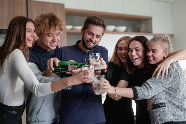 Veselí mladí přátelé otevírají láhev šampaňského — Stock fotografie