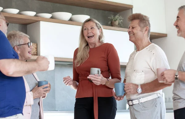 Группа друзей с чашками кофе, стоящих на домашней кухне . — стоковое фото