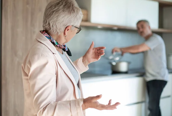Amable anciana hablando de pie en la cocina  . — Foto de Stock