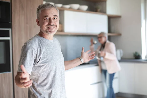 Дружній зрілий чоловік стоїть на своїй кухні  . — стокове фото