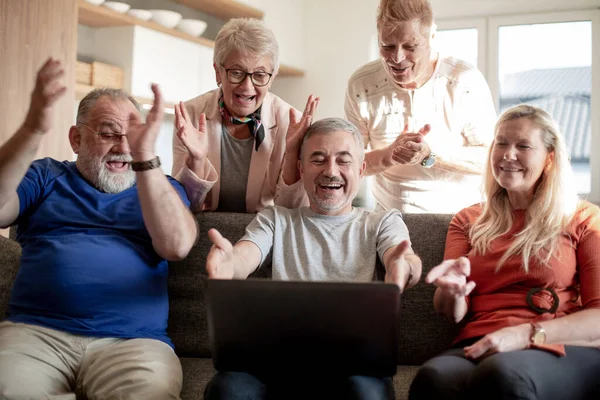 Groupe de vieux amis regarder une vidéo sur leur ordinateur portable . — Photo