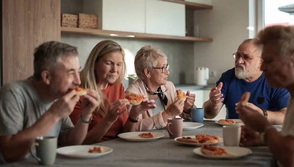 Mature amis assis à la table dans la cuisine de la maison . — Photo