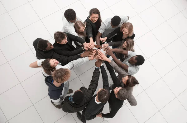 Grupp unga framgångsrika människor står runt händer tillsammans — Stockfoto