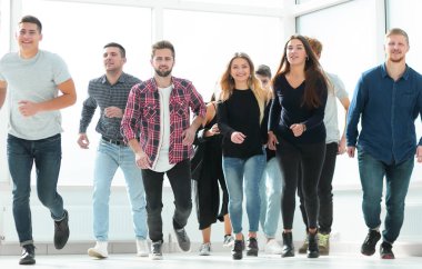 Yeni bir ofiste başlayan bir grup mutlu genç çalışan.