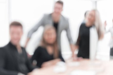 Ofis masasında oturan bir grup genç iş adamı.