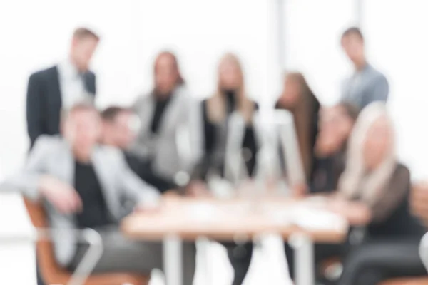 Verschwommenes Bild einer Gruppe von Mitarbeitern an einem Schreibtisch im Büro — Stockfoto