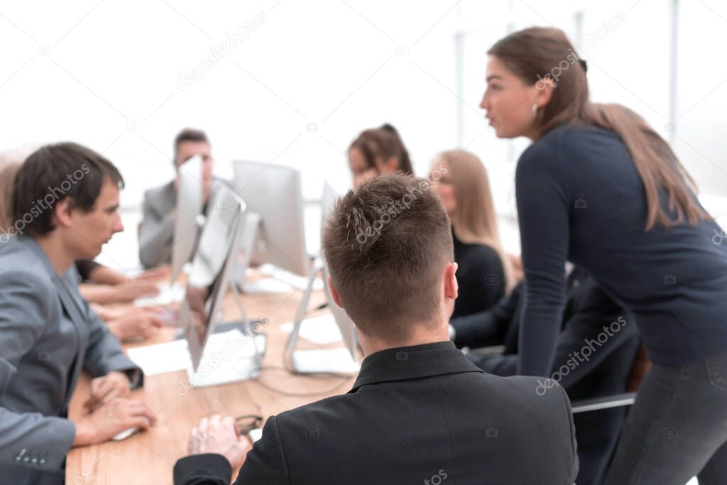 young employee sitting at a Desk about looking at the camera.