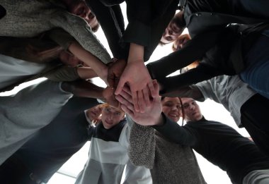 Alt manzara. Bir grup mutlu genç insan ellerinden bir kule yapıyorlar. .