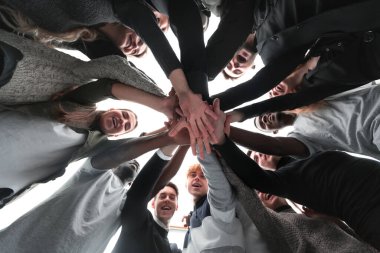 Alt manzara. Bir grup mutlu genç insan ellerinden bir kule yapıyorlar. .