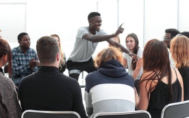 Kapat. Çemberin içinde bir grup farklı genç insan oturuyor.