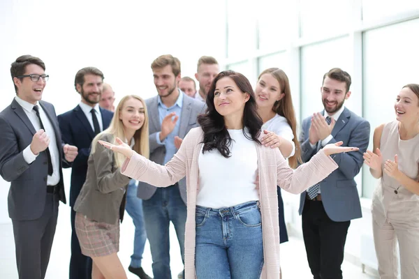 Счастливая деловая леди, стоящая перед аплодирующей командой сотрудников . — стоковое фото